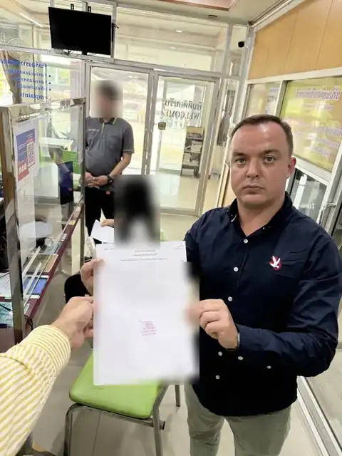 客户在暖武里府Plai Bang警察局,手持撤案后的警方文件,个人信息已隐去