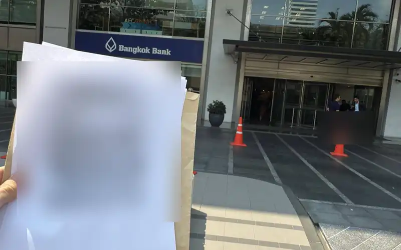 Documents for a bank unfreeze case outside a Bangkok Bank branch, passport copy hidden