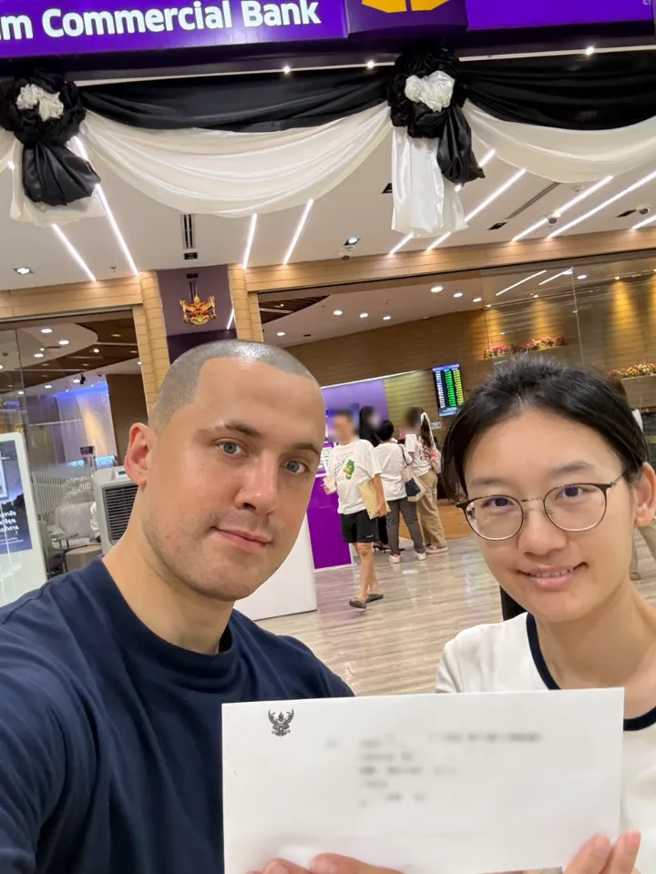 Mike from UnblockPro.Asia and the client at an SCB branch with the police release letter (document text hidden)